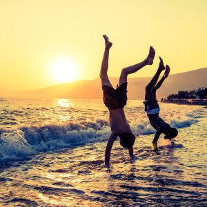 Zwei Jungs machen am Strand Handstand